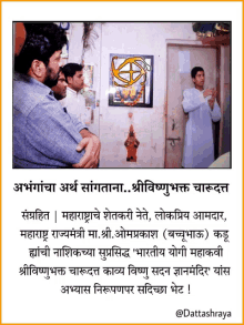 a group of men are standing in front of a door with a picture of a man on the wall above them