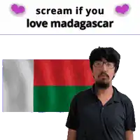 a man with glasses stands in front of a flag with the words scream if you love madagascar