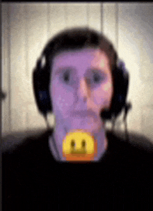 a blurry picture of a man wearing headphones and a smiley face on his neck .