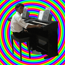 a man sits at a keyboard with a rainbow background