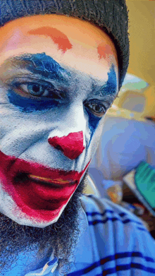 a man with a beard has his face painted like the joker