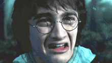 harry potter is wearing glasses and making a funny face in a close up of his face .