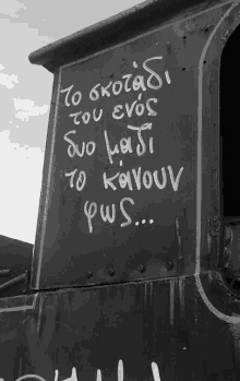 a black and white photo of a sign that says " to skozadi tou enos "