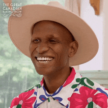 a man wearing a hat and a floral shirt is smiling in front of the great canadian baking show logo