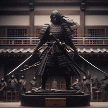 a statue of a samurai with two swords is displayed in front of the museum bola