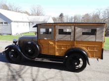 a ford woody wagon is parked in front of a house