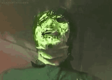 a close up of a person 's face with green icing on it .