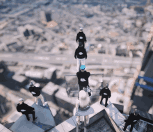 a group of people standing on top of a building wearing black sweatshirts with a skull on the front