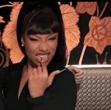 a woman in a black suit is eating a candy cane .