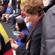 a group of people are sitting in chairs and one woman is holding a piece of paper that says ' i love you '