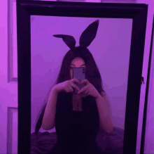 a girl wearing bunny ears is taking a picture of herself in the mirror