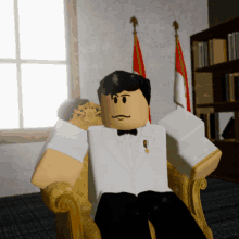 a man in a tuxedo sits in a chair in front of flags