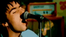 a close up of a man singing into a microphone