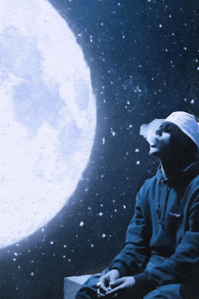 a man smoking a cigarette in front of the full moon