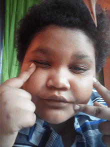 a young boy is making a face with his fingers