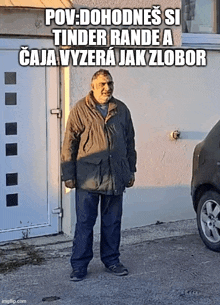 a man in a jacket is standing in front of a garage door with a car in the background .