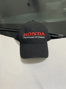 a black honda hat is sitting on a white table