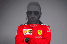 a man wearing sunglasses and a red ferrari jacket