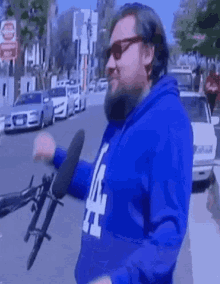 a man wearing a blue la dodgers sweatshirt is holding a microphone