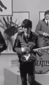 a man is playing a guitar in a black and white photo of a band .