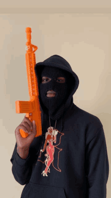 a man in a ski mask is holding a toy gun