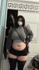 a woman wearing a mask and shorts is standing in front of a sign that says ' a ' on it