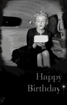 a black and white photo of a woman blowing out a candle and the words happy birthday