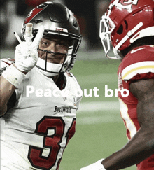 a buccaneers football player giving a peace sign next to a chiefs player