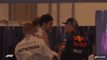 a group of racing drivers are standing next to each other in a room .