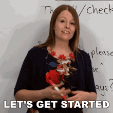 a woman stands in front of a white board with the words " let 's get started " on it