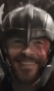 a close up of a man wearing a helmet with blood on his face