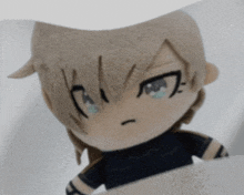 a close up of a stuffed anime character with a black shirt on