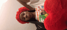 a young girl wearing a nickelodeon shirt and a red hat