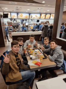 a group of young men are sitting at a table in a mcdonald 's restaurant