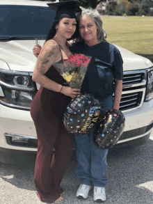 a woman holding a bouquet of flowers and a congratulations balloon