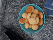 a blue bowl filled with cookies on a granite countertop