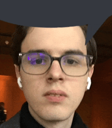 a close up of a man wearing glasses and earbuds