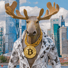 a statue of a moose wearing gold chains and a gold coin with the letter b on it