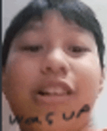 a close up of a young boy 's face with the word jesus written on his face .