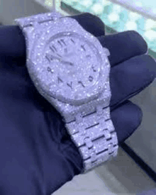 a close up of a person holding a watch with diamonds on it .