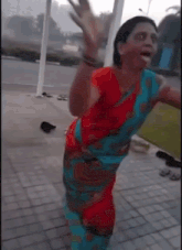 a woman in a red and blue dress is dancing with her arms outstretched
