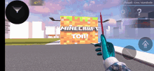 a hand holding a gun in front of a minecraft sign