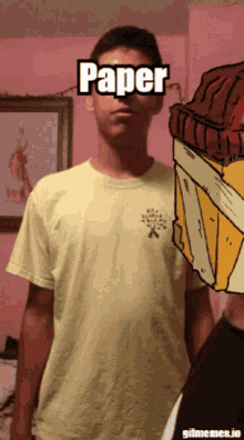 a man wearing a yellow shirt has the word paper on his forehead