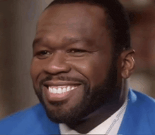 a man with a beard is smiling in a blue jacket