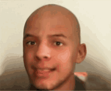 a close up of a young man 's face with a bald head