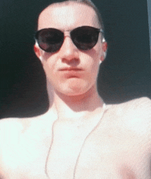 a shirtless man wearing sunglasses and headphones