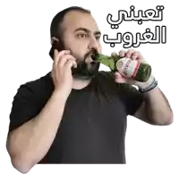 a man talking on a cell phone while drinking a bottle of amara