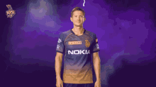 a man in a nokia shirt stands in front of a purple backdrop