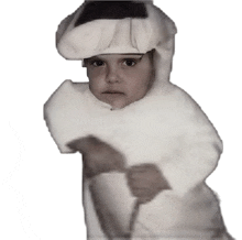 a little girl is wearing a white costume with a hat on her head