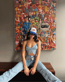 a woman wearing a sesame street hat sits on a table in front of a painting